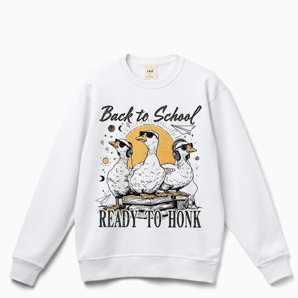 A white sweatshirt with a graphic design featuring three ducks and the text "Back to School READY to HONK" printed on it.