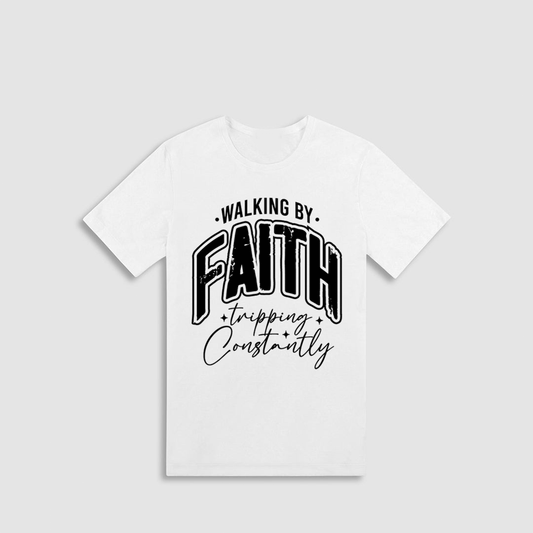 A white t-shirt with the text "WALKING BY FAITH" and "TRIPPING CONSTANTLY" printed on it.