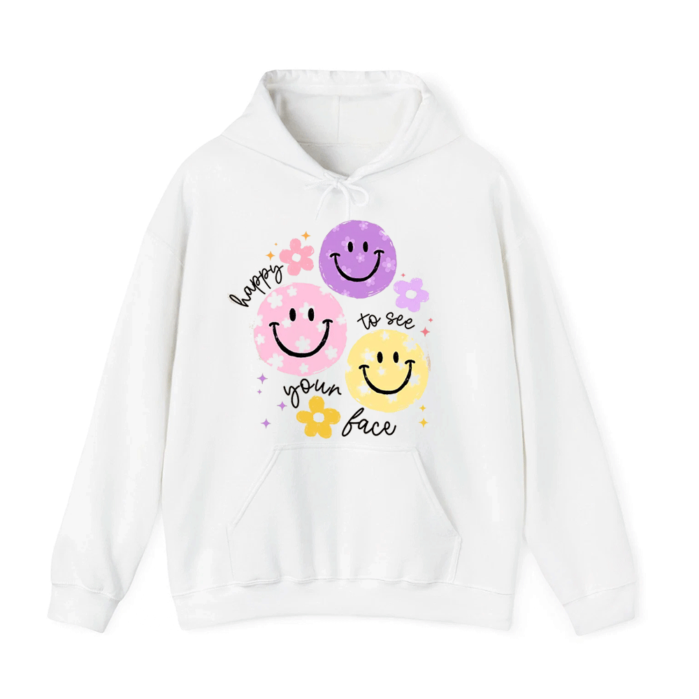 A white hoodie with a graphic design featuring three smiling faces and the text "happy to see your face" written around them.