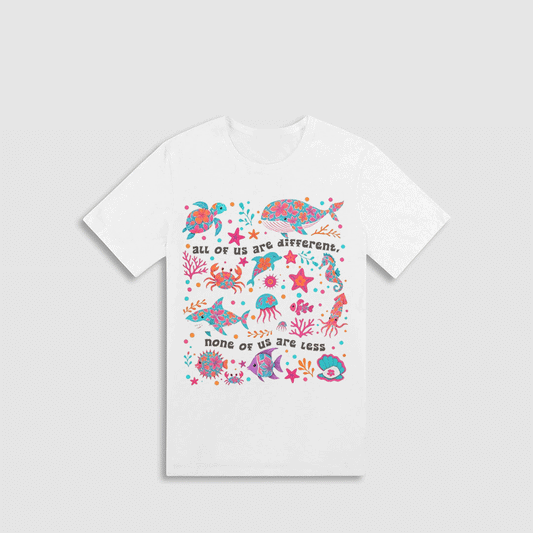 A white t-shirt with a colorful graphic design depicting various marine life, including fish, sharks, and sea creatures, along with the text "all of us are different. none of us are less".