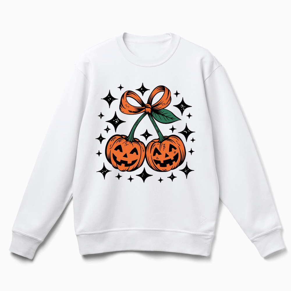 A white sweatshirt with a graphic design featuring two jack-o'-lanterns and a bow, surrounded by stars.