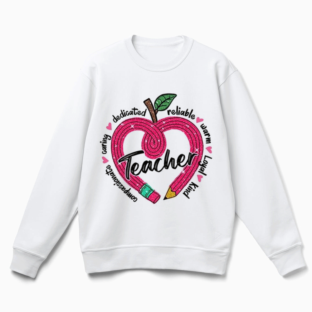 A white sweatshirt with a graphic design featuring an apple with a heart shape and the word "Teacher" written inside it.