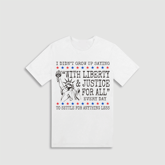 A white t-shirt with a graphic design featuring the Statue of Liberty and text that reads "I didn't grow up saying 'with liberty & justice for all' every day to settle for anything less".