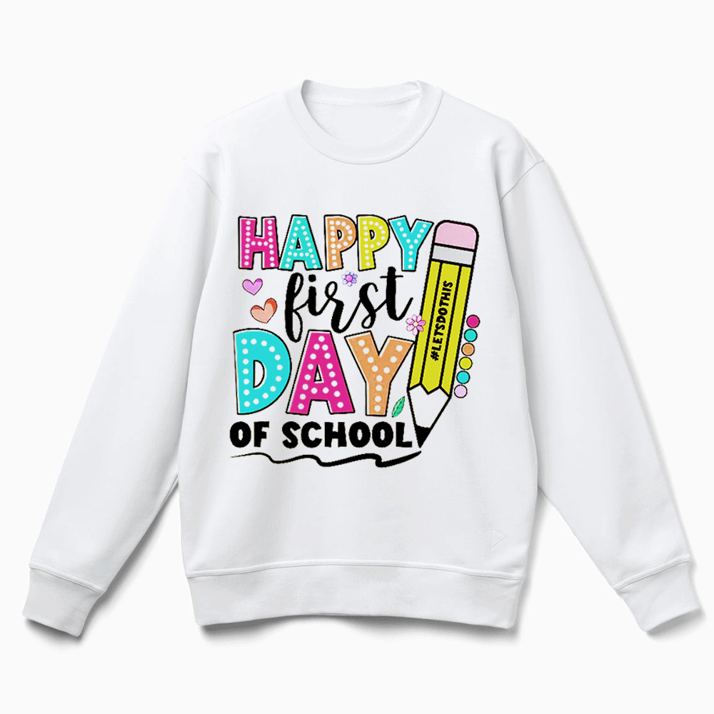 A white sweatshirt with a colorful graphic design that says "HAPPY FIRST DAY OF SCHOOL" and features a pencil and other school-related elements.