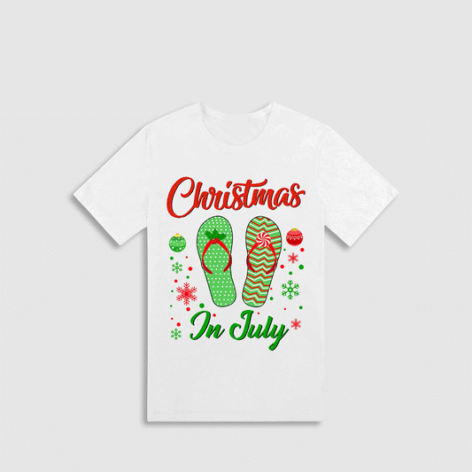 A white t-shirt with a Christmas and July theme design. The design includes a pair of green and red flip-flops, snowflakes, and Christmas ornaments. The text on the shirt reads "Christmas In July".