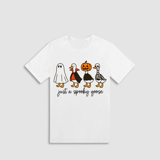 A white t-shirt with a graphic design featuring a group of cartoon-style ducks dressed in Halloween costumes, including a ghost, pumpkin, skeleton, and apron. The text below the image says "Just a spooky goose".