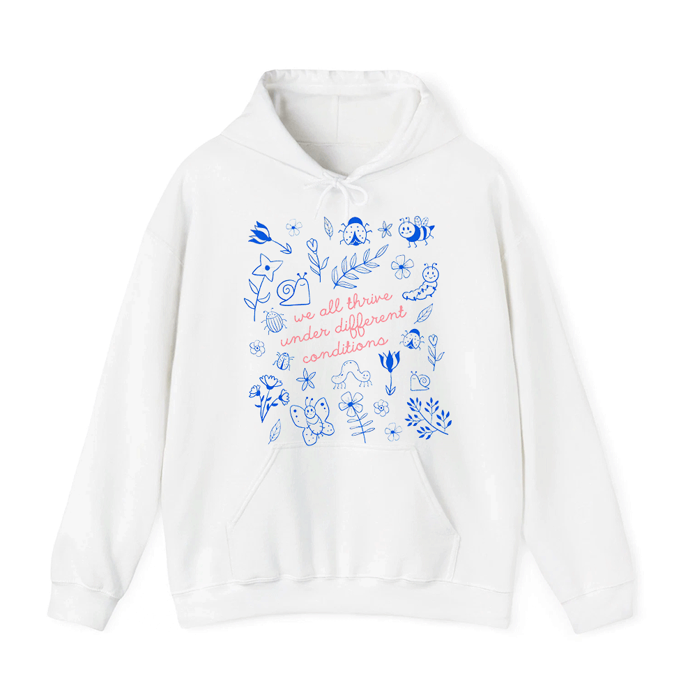 A white hoodie with a printed design featuring various elements such as flowers, leaves, and insects. The text on the hoodie reads "we all thrive under different conditions".