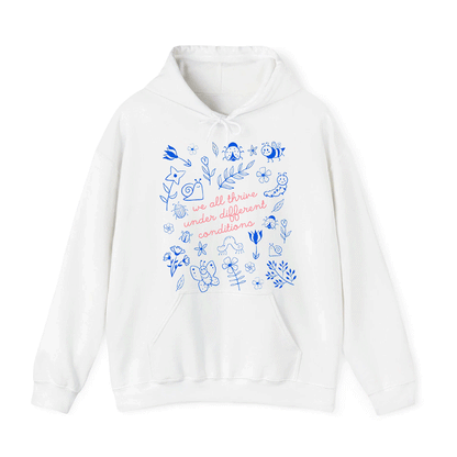 A white hoodie with a printed design featuring various elements such as flowers, leaves, and insects. The text on the hoodie reads "we all thrive under different conditions".