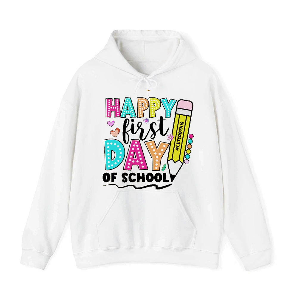A white hoodie with a colorful graphic design that says "HAPPY FIRST DAY OF SCHOOL" and features various school-related elements such as a pencil, hearts, and a book.
