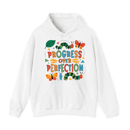 A white hoodie with a colorful graphic design featuring a caterpillar, butterflies, and the text "PROGRESS OVER PERFECTION".