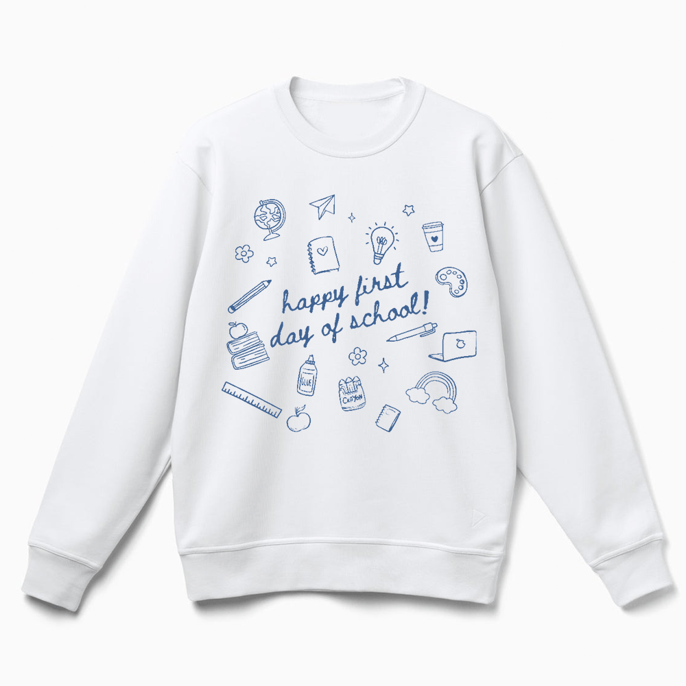 A white sweatshirt with a graphic design featuring various school-related items and the text "happy first day of school!"