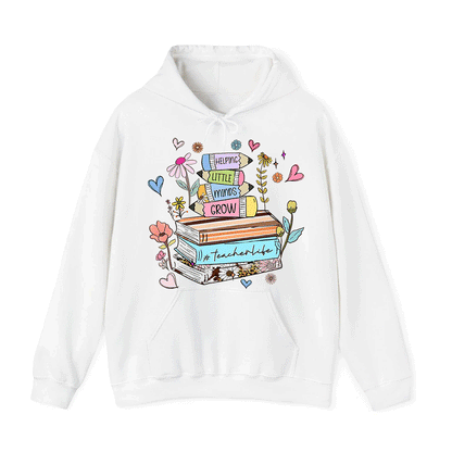 A white hoodie with a colorful graphic design featuring a stack of books surrounded by flowers, hearts, and other decorative elements.