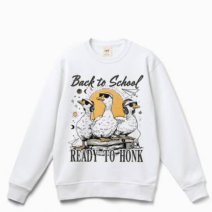 A white sweatshirt with a graphic design featuring three ducks and the text "Back to School READY to HONK" printed on it.