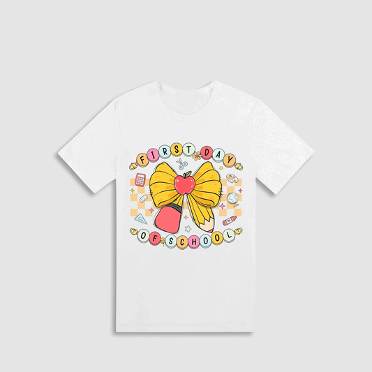 A white t-shirt with a colorful graphic design featuring a yellow bow, a red apple, and various school-related icons.