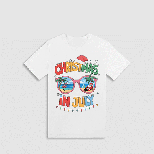 A white t-shirt with a colorful graphic design featuring sunglasses, palm trees, and the text "Christmas in July"