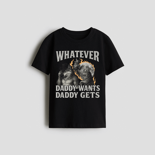 The image is a black t-shirt with a graphic design featuring a cat and a dog, along with the text "WHATEVER Daddy Wants Daddy Gets" printed on it.