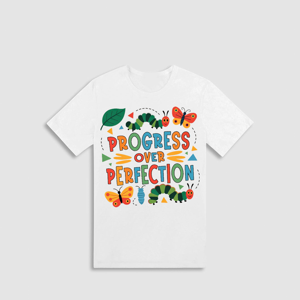 A white t-shirt with a colorful graphic design featuring the text "PROGRESS OVER PERFECTION" surrounded by various insects and butterflies.