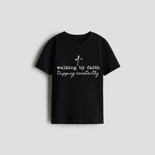 A black t-shirt with white text that reads "walking by faith constantly".