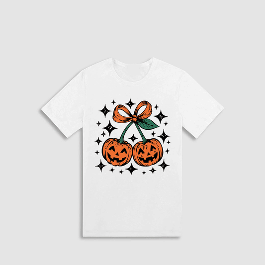 A white t-shirt with a graphic design featuring two jack-o'-lanterns and a bow, surrounded by stars.