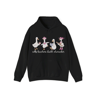A black hoodie with a graphic design featuring four cartoon ducks, each with a unique activity or pose, and the text "silly teachers build character" below the image.